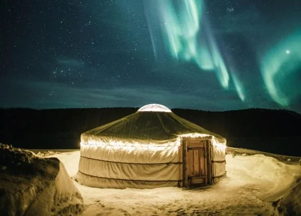Lit yurt under the northern lights